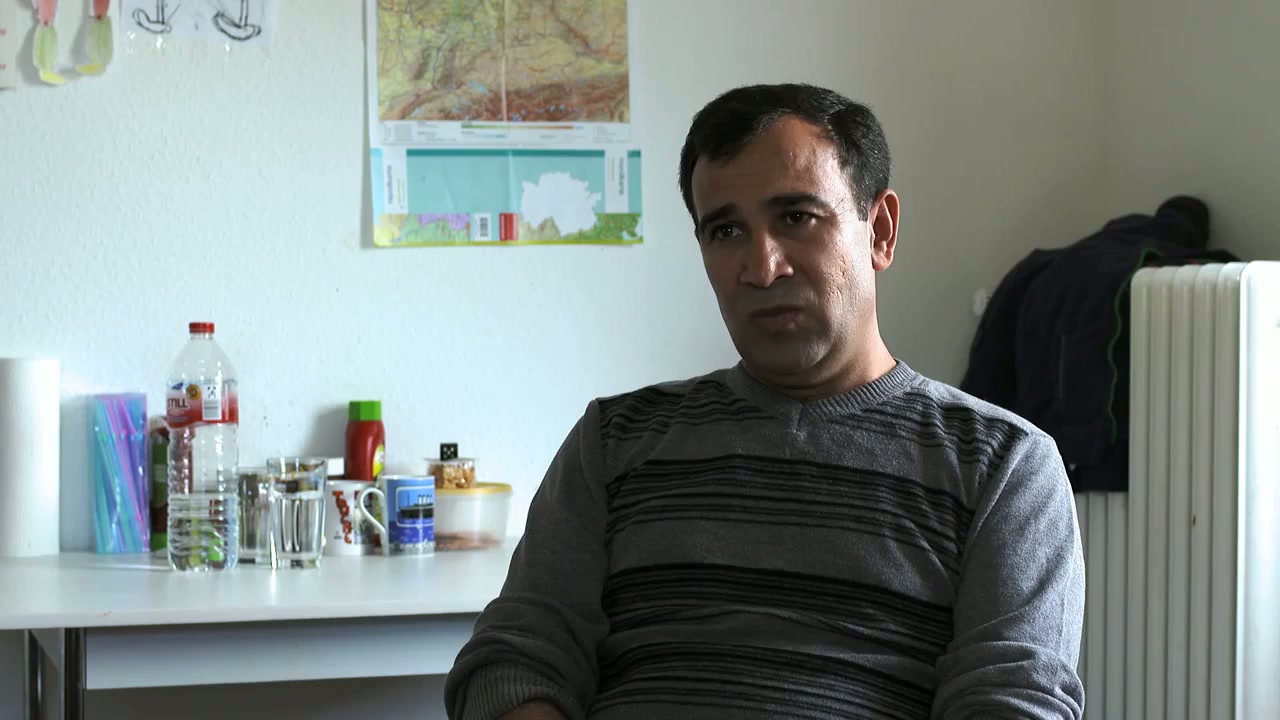 A refugee at the kitchen table of his new apartment