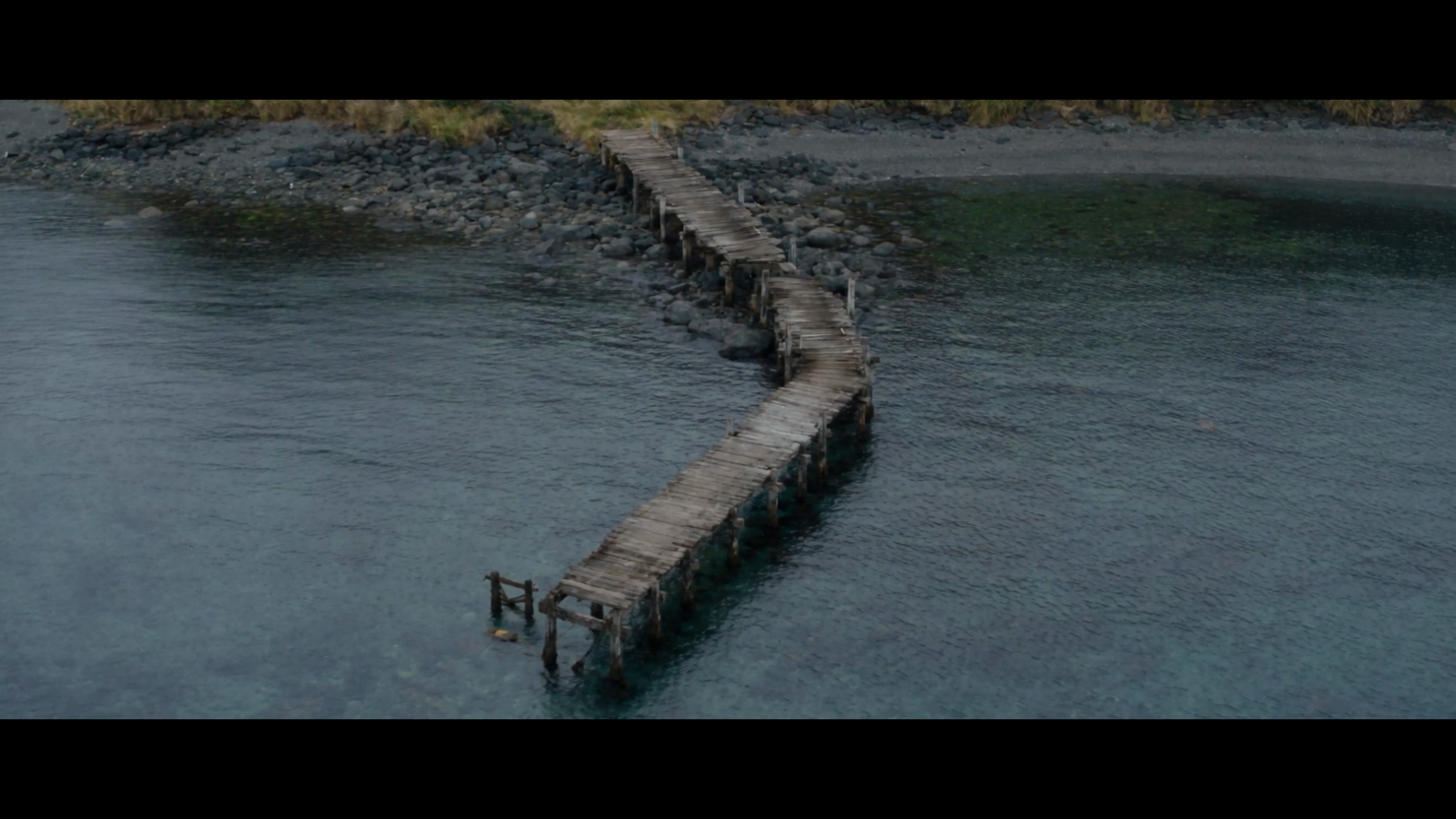 The curved wooden pier seen from above the shoreline